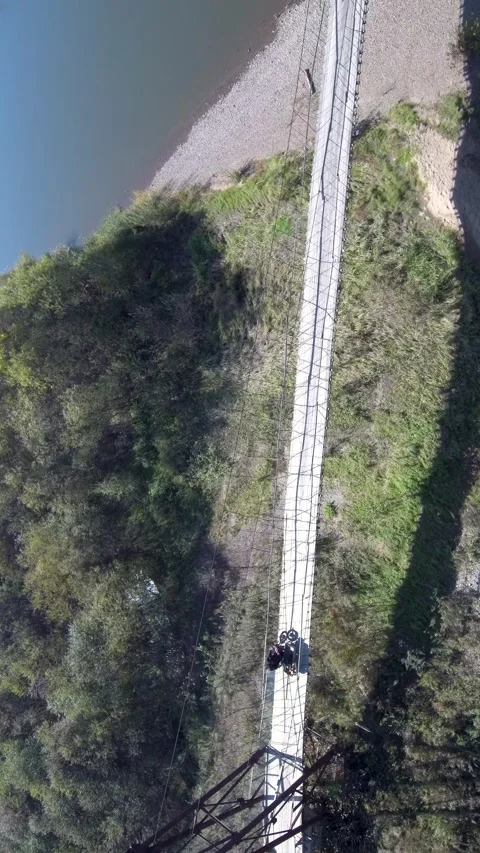Top Down Drone Tracking Motorcycle on Suspension Bridge Stock Footage 339104577