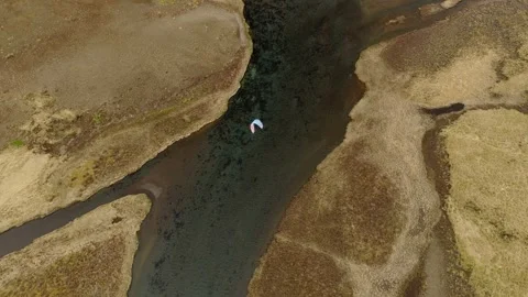 Top-down drone tracking paraglider above volcanic wetlands at Herdisarvik 스톡 동영상 344125297