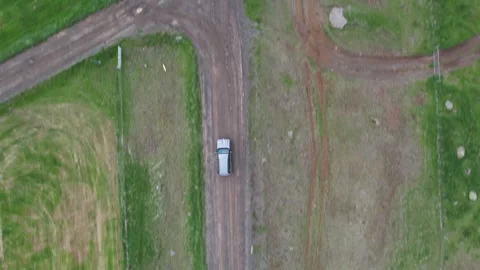 Top down drone tracking SUV on gravel road between fields, Snaefellsnes Stock Footage 346552376