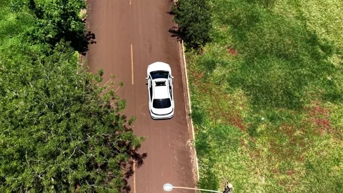 Top Down Drone Tracking White Car Driving Toward Stop Sign Video stock 346853064