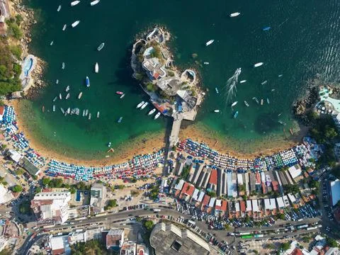 Top-down drone view of Acapulco's Caleta Beach, vibrant umbrellas, many people Fotos Stock