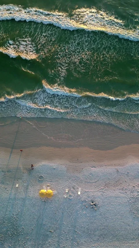 Top Down Drone View of Beach Waves and Yellow Umbrellas at Sunset Stock Footage 330703520