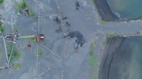 Top Down drone view of black sand aggregate stockpile and coastal site Stock Footage 337793570