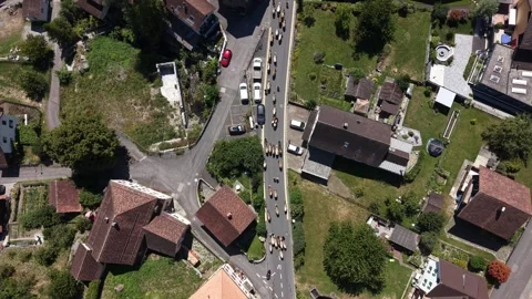 Top down drone view of cattle herd filling main village road in Switzerland Stock Footage 341840329