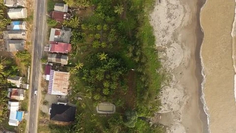 Top-Down Drone View of Coastal Village, Beachfront Vegetation and Shoreline Stock Photos