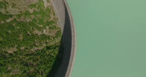 Top-Down Drone View of Dam with Turquoise Reservoir Revealing Massive Wall Stock Footage 341917130