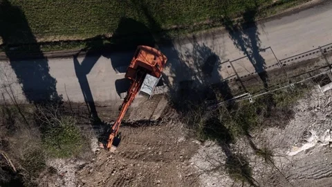 Top down drone view of excavator digging roadside trench for infrastructure Stock Footage 331795437