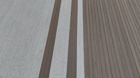 Top-down drone view of finely leveled alternating light and dark soil strips Stock Footage 310180150