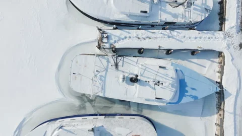 Top down drone view of fishing boats in frozen water Stock Footage 334175059