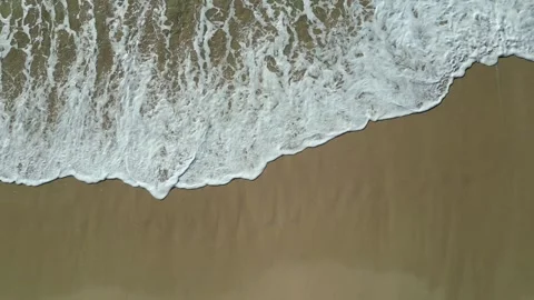 Top down drone view of foamy surf washing over wet sand in Hawaii Stock-Footage 348263770