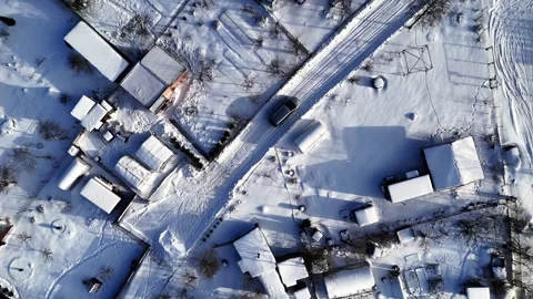 Top Down Drone View Following Car Driving Through Snowy Rural Village Video stock 337901238