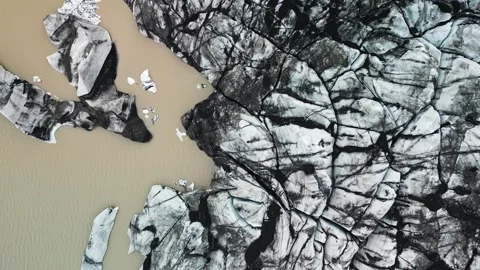 Top down drone view of fractured Icelandic glacier and lake 4K Stock-Footage 344250993