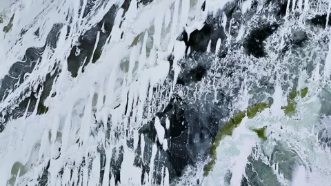 Top-down drone view of frozen sea covered in snow and fractured ice sheets Stockbeeldmateriaal 331338407