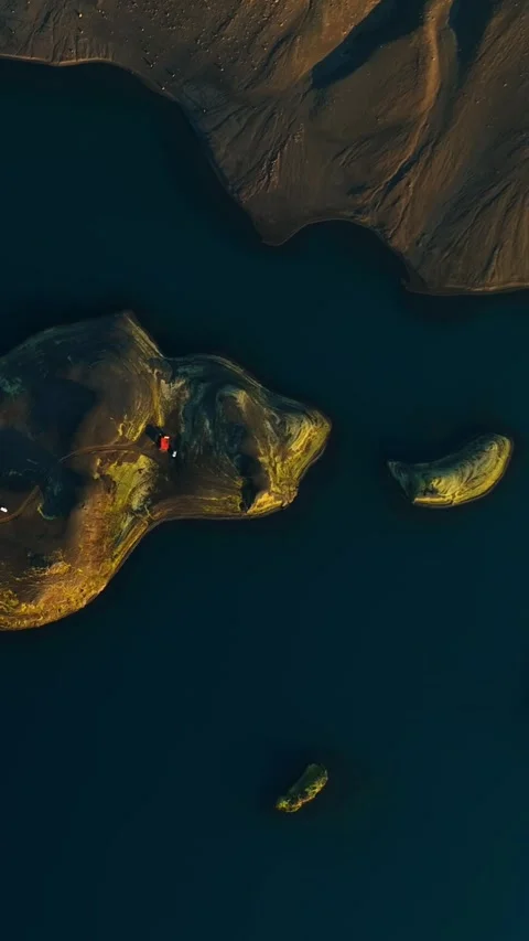 Top-down drone view of a golden sandbar island with two small islets in dark Stock Footage 330903854
