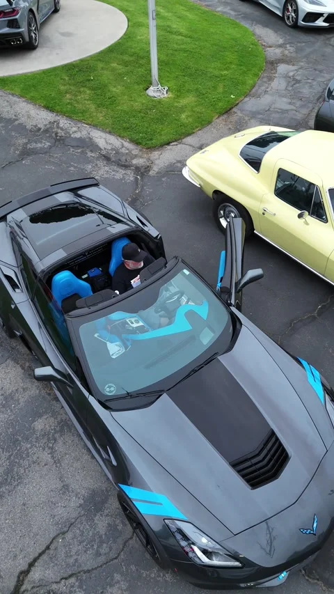 Top-down drone view of grey Corvette with blue interior at car meet Stock Footage 346732462