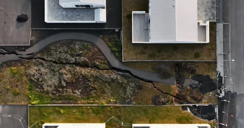 Top-down drone view in Grindavik, Iceland, showing a long fissure crossing Vídeo Stock 345994512