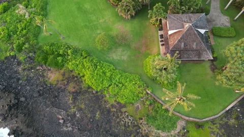Top down drone view of a house on a lawn beside lava coast in Hawaii Stock-Footage 348251060