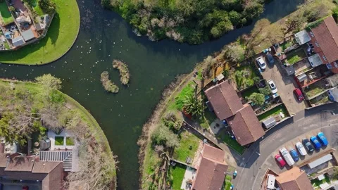 Top-down drone view of houses along a canal with bridges, taken in daytime Stock Footage 332622926