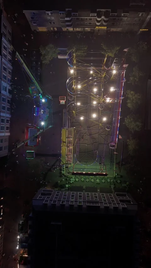 Top down drone view of illuminated fairground roller coaster at night 動画素材 345255474