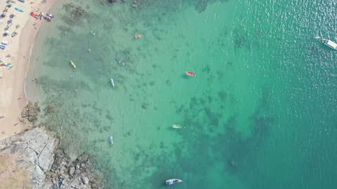 Top-down drone view of kayaks and snorkelers near rocky beach, Phuket Stock Footage 318779545