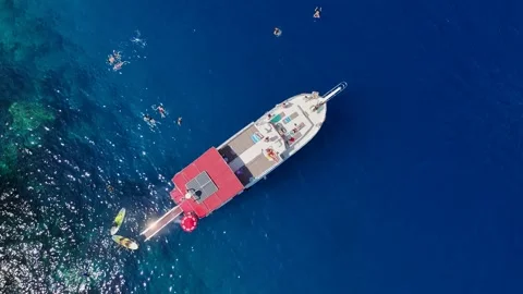 Top Down Drone View of a Large Tour Boat in Deep Blue Open Sea Stock Footage 317202483