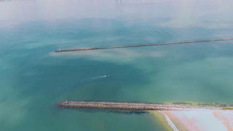Top-down drone view of a lone boat between concrete breakwaters Stock Footage 337028422
