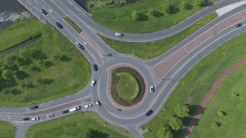 Top down drone view of modern roundabout with traffic and greenery Video stock 337351359