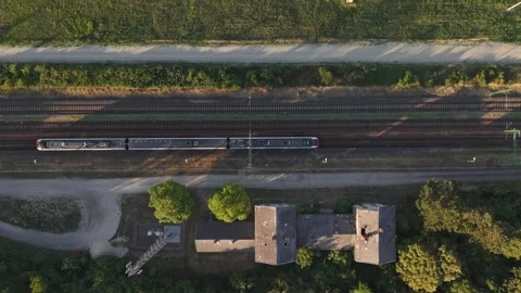 A top-down drone view of a modern passenger train traveling along parallel Stock Footage 338191711