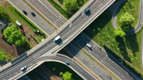 Top-down drone view of multilane road and curved overpass over railway tracks Stock Footage 308646315