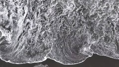 Top down drone view of ocean waves breaking on black sand beach, New Zealand Stock Footage 339017844