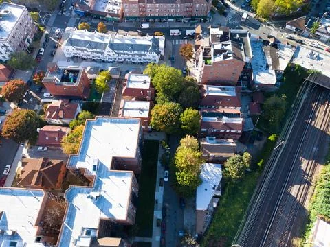 Top down drone view over a dense city block of rooftops, streets and trees Фото