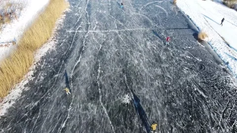 Top Down Drone View On People Ice Skating On Frozen Lake In Snow-Covered Land Stock Footage