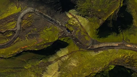 Top-down drone view of an off-road vehicle driving on winding mountain tracks 動画素材 331326521