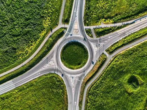Top Down Drone View of a Road Roundabout Surrounded by Green Fields Stock Photos