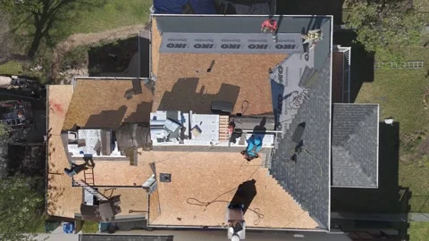 Top down drone view of roofers replacing residential house shingles Stock Footage 335427242