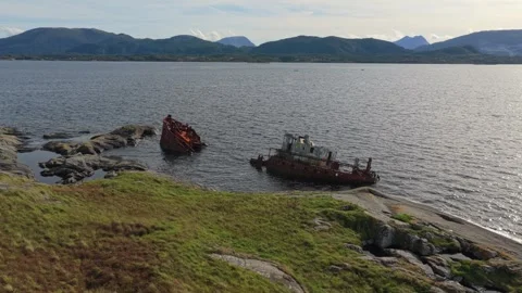 Top-down drone view of ruined ship stranded on rocky ocean coast Stock Footage 320732615