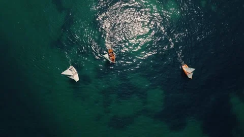 Top down drone view of sailboats and small boats on clear turquoise ocean water Stock Footage 330921312