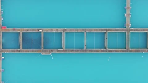 Top-down drone view of a salmon farm with rectangular pens in vivid blue water 스톡 동영상 313342026