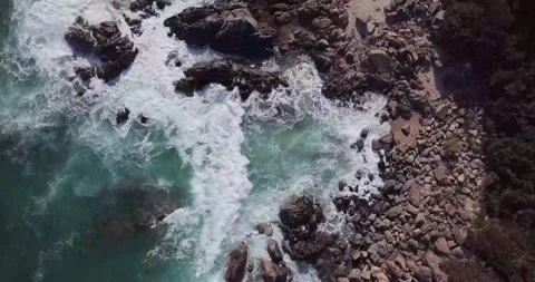 Top-Down Drone View of Sea Waves Crashing onto a Sandy Beach Shore Stock Footage 340557569