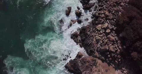 Top-Down Drone View of Sea Waves Crashing onto a Sandy Beach Shore Stock Photos