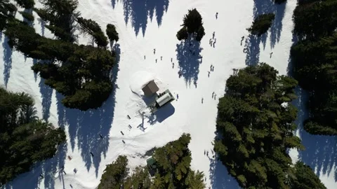 Top-Down Drone View of Skiers and Shadows around Ski Lift Station 動画素材 348414215