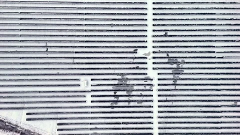 Top-down drone view of a snow-covered solar panel array in neat parallel rows Video stock 326292883