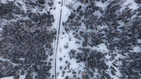 Top down drone view of snowy forest road and vehicle in Xinjiang, China Stock Footage 341842275