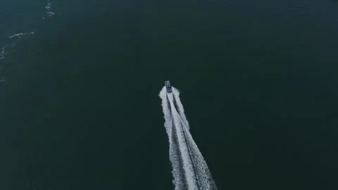 Top down drone view of speedboat leaving wake on open water Video stock 337351398