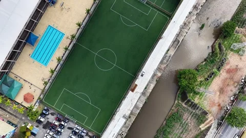 Top-Down Drone View of Sports Complex, Soccer Pitch, Pools, and River Canal 動画素材 344577497