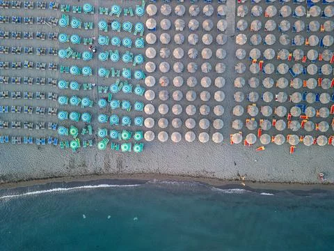 Top Down Drone View of Straw Umbrellas and Sea Water Velipoja Beach Stock Photos