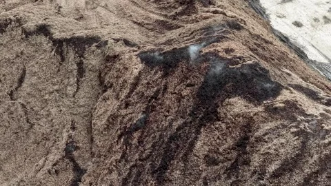 Top down drone view of tire tracks surrounding a dark material pile on the Stock Footage 341098739
