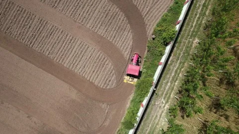 Top down drone view of tractor turning while ploughing field 스톡 동영상 333271549