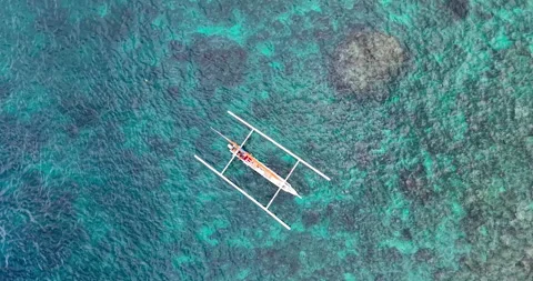 Top Down Drone View of Traditional Jukung Boat Over Coral Reef in Bali Stock Footage 334372506