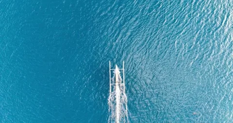 Top Down Drone View of Traditional Boat Cutting Through Blue Ocean in Bali Stock Footage 334373874